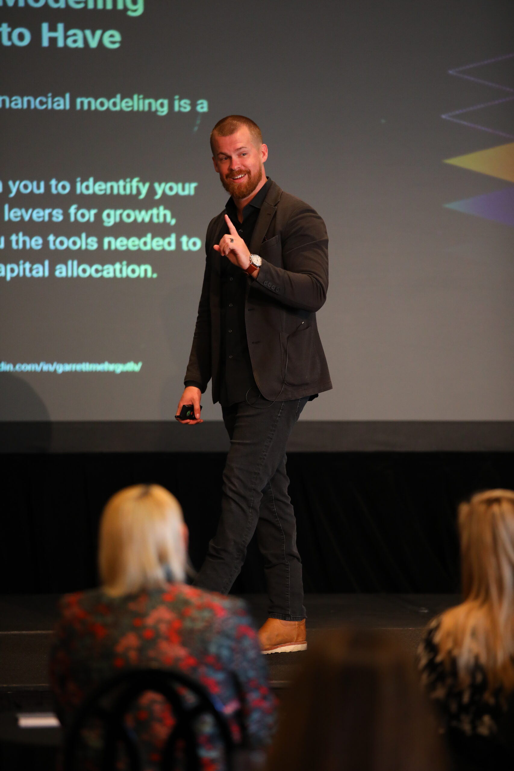 Garrett Mehrguth speaking on stage at a B2B marketing conference